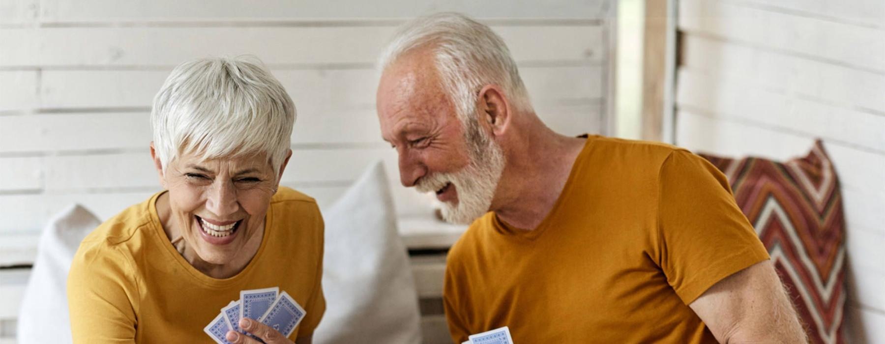 a man and woman sitting at a table playing cards