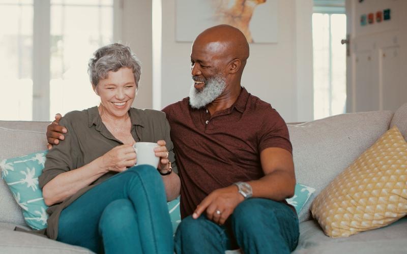 smiling, older couple, sit together on a couch