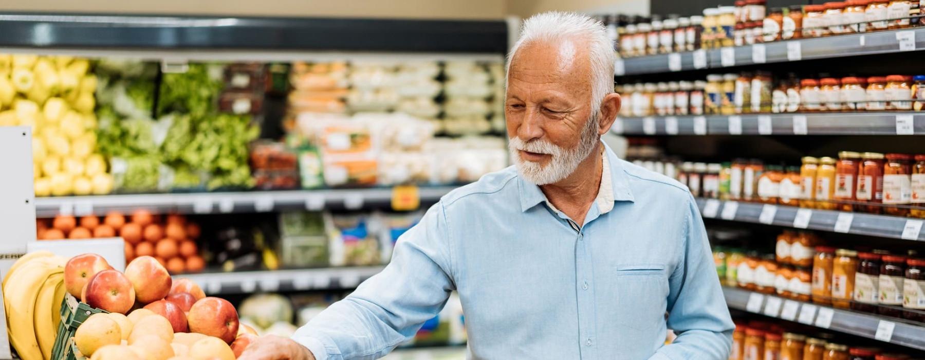 a person holding a shopping cart in a grocery store